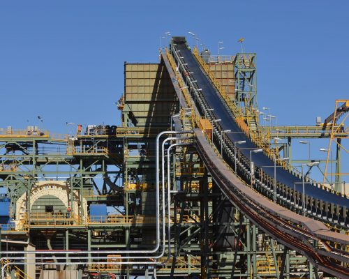 A section of black conveyor belt on an ore processing facility. Vertical shot.